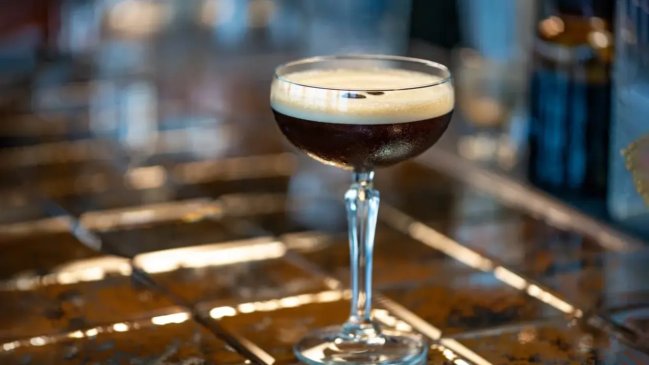Idealny espresso martini przepis na orzeźwiający drink. Ciemny napój z pianką w kieliszku.