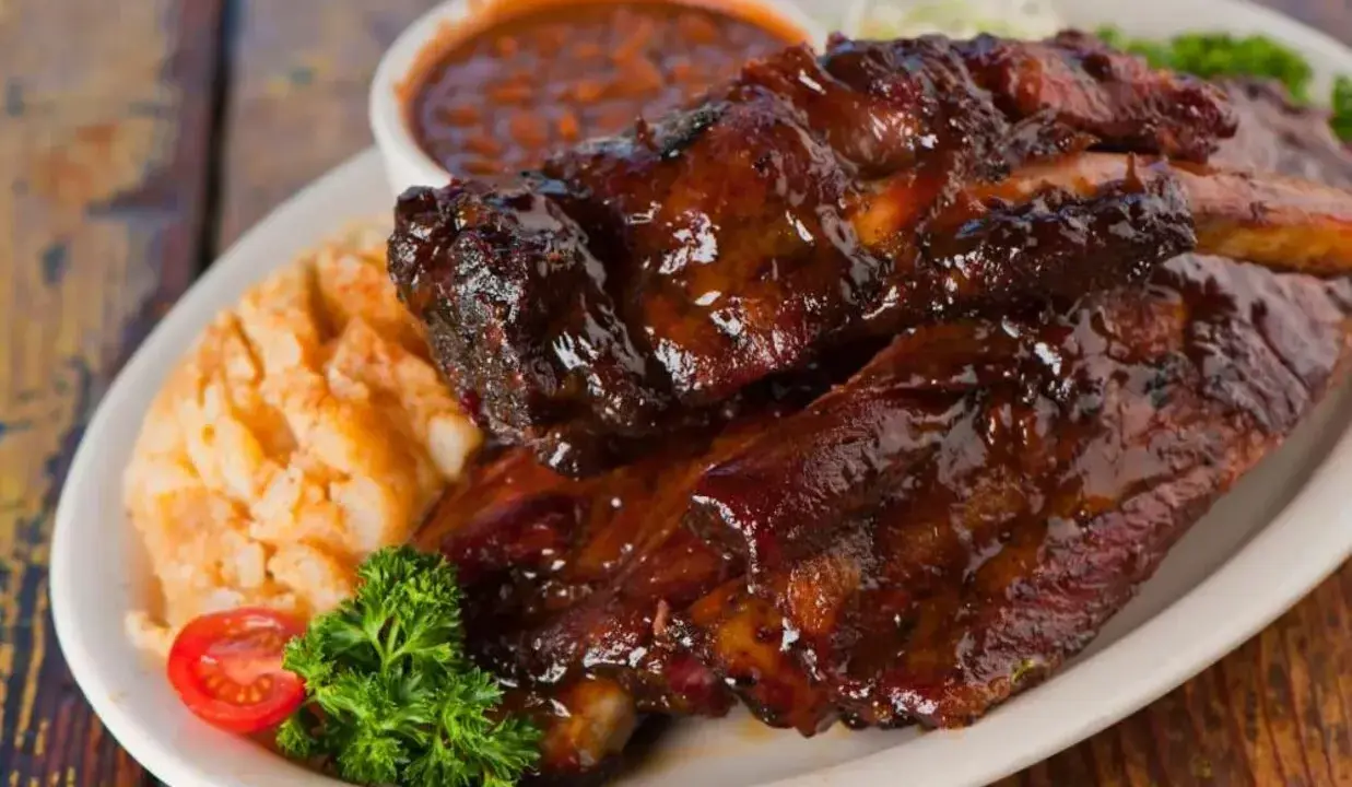 Soczyste żeberka w sosie BBQ, podane z puree ziemniaczanym i fasolką. Idealne pytanie: jakie przyprawy do żeberek?
