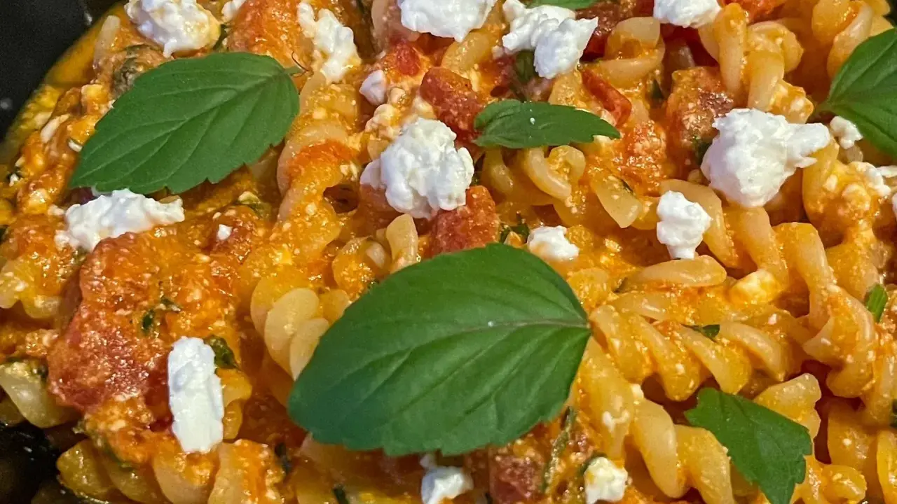 Pyszne fusilli z sosem pomidorowym, kawałkami sera feta i świeżą bazylią. Idealne danie dla miłośników pomidorów z fetą.