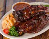 Soczyste żeberka w sosie BBQ, podane z puree ziemniaczanym i fasolką. Idealne pytanie: jakie przyprawy do żeberek?