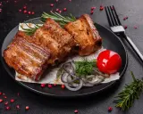 Soczysta żeberka jak piec, podane z pomidorkiem, cebulą i rozmarynem.