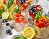 Kilka szklanek z owocami i lodem, idealne na kwaśny orzeźwiający drink. W środku truskawki, borówki, cytryny i mięta.