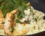 Pyszny filet z sandacza ze skórą z piekarnika, podany z kremowym sosem i ziołami.