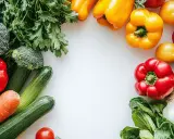 Kolorowe warzywa: papryki, pomidory, brokuły, cukinie, marchew, czosnek i zioła, tworzące ramkę. Idealne do potraw z bogatym smakiem umami.