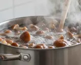 Grzyby gotują się w garnku, parując obficie. Czas gotowania grzybów zależy od ich rodzaju.