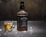 Butelka Jack Daniels i szklanka z whisky, z lodem i błyszczącymi drobinkami. Zastanawiasz się nad Jack Daniels kcal?