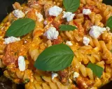 Pyszne fusilli z sosem pomidorowym, kawałkami sera feta i świeżą bazylią. Idealne danie dla miłośników pomidorów z fetą.