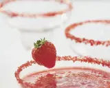 Orzeźwiająca margarita z truskawkami, ozdobiona cukrem i świeżym owocem, czeka na spróbowanie.
