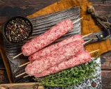 Surowe kebaby na patyczkach, miseczka pieprzu i tymianek. Idealne składniki na kofta libańska przepis.
