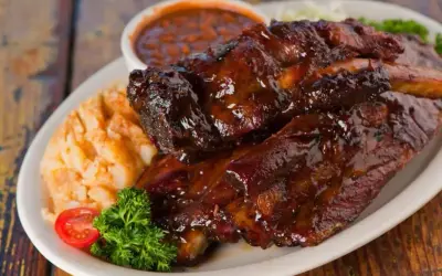Soczyste żeberka w sosie BBQ, podane z puree ziemniaczanym i fasolką. Idealne pytanie: jakie przyprawy do żeberek?