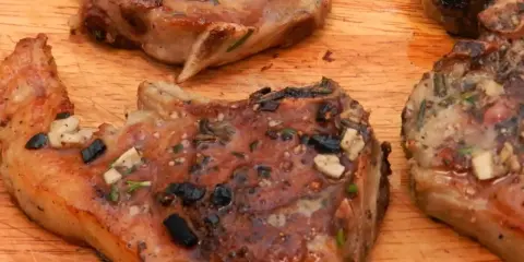 Aromatyczne kotlety jagnięce z kością, pieczone w piekarniku, z czosnkiem i ziołami.