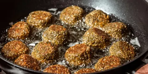 Falafelki smażą się na głębokim oleju w czarnej patelni. Idealny sposób, na czym najlepiej smażyć, by były chrupiące!