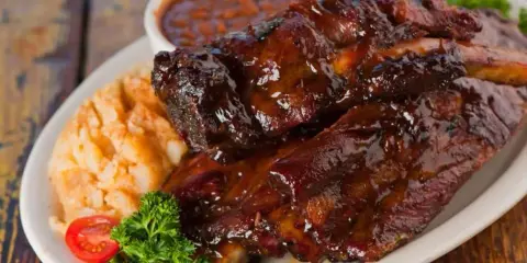 Soczyste żeberka w sosie BBQ, podane z puree ziemniaczanym i fasolką. Idealne pytanie: jakie przyprawy do żeberek?