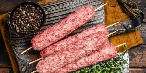 Surowe kebaby na patyczkach, miseczka pieprzu i tymianek. Idealne składniki na kofta libańska przepis.
