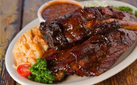 Soczyste żeberka w sosie BBQ, podane z puree ziemniaczanym i fasolką. Idealne pytanie: jakie przyprawy do żeberek?