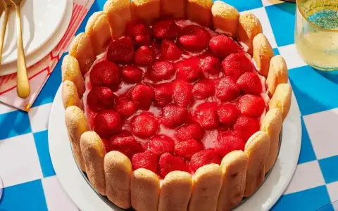 Pyszny deser z truskawkami, otoczony biszkoptami. Idealny na letnie popołudnie.