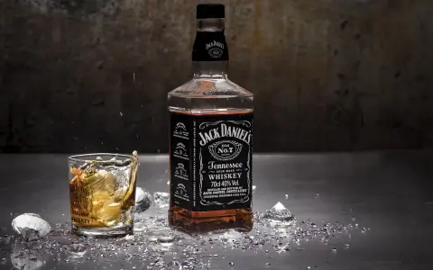 Butelka Jack Daniels i szklanka z whisky, z lodem i błyszczącymi drobinkami. Zastanawiasz się nad Jack Daniels kcal?