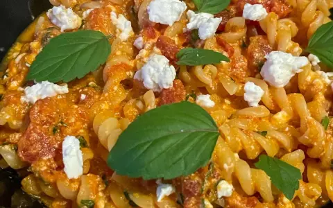 Pyszne fusilli z sosem pomidorowym, kawałkami sera feta i świeżą bazylią. Idealne danie dla miłośników pomidorów z fetą.