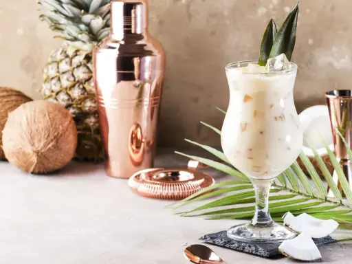 Kremowe drinki z malibu, kokosy, ananas i miedziany shaker tworzą tropikalny klimat.