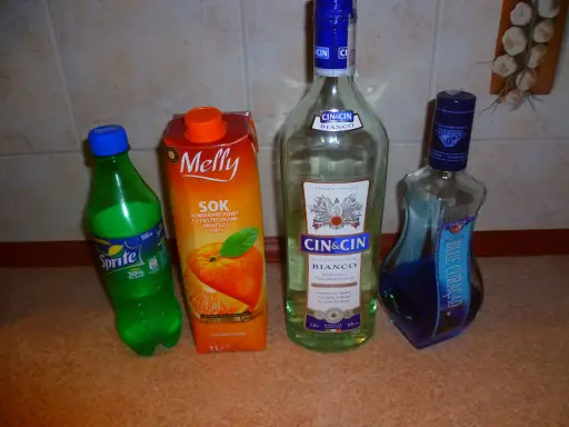 Składniki na drinki z Żabki: Sprite, sok pomarańczowy, Cin&Cin Bianco i Blue Curacao.