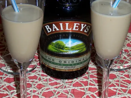Dwa kieliszki z prostym drinkiem z Baileys, obok butelki tego irlandzkiego likieru. Idealny na wieczór.