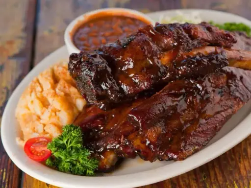 Soczyste żeberka w sosie BBQ, podane z puree ziemniaczanym i fasolką. Idealne pytanie: jakie przyprawy do żeberek?