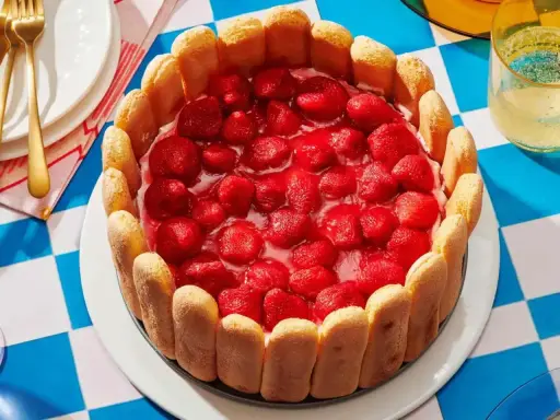 Pyszny deser z truskawkami, otoczony biszkoptami. Idealny na letnie popołudnie.