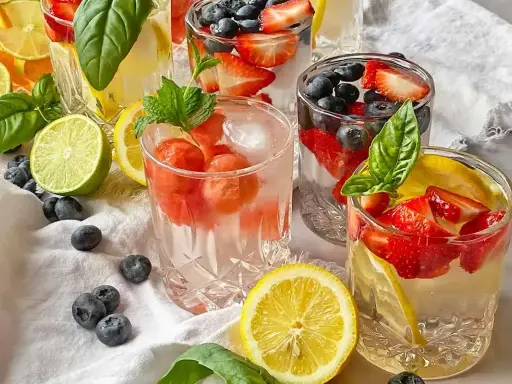 Kilka szklanek z owocami i lodem, idealne na kwaśny orzeźwiający drink. W środku truskawki, borówki, cytryny i mięta.
