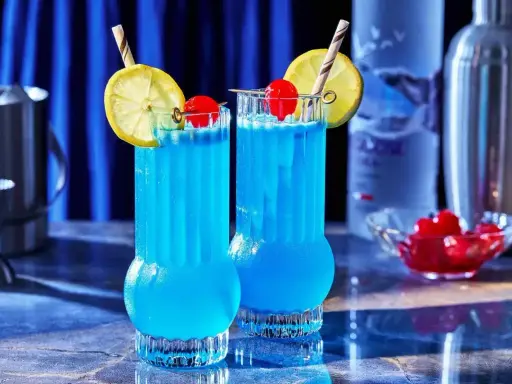 Dwa orzeźwiające drinki Blue Lagoon z cytryną i wiśnią, gotowe do podania.