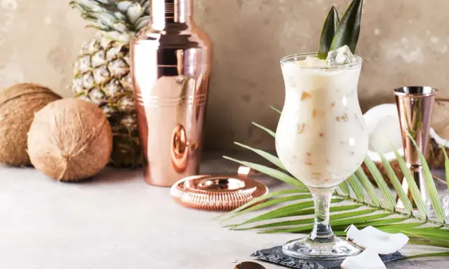 Kremowe drinki z malibu, kokosy, ananas i miedziany shaker tworzą tropikalny klimat.