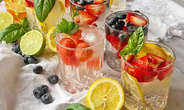 Kilka szklanek z owocami i lodem, idealne na kwaśny orzeźwiający drink. W środku truskawki, borówki, cytryny i mięta.