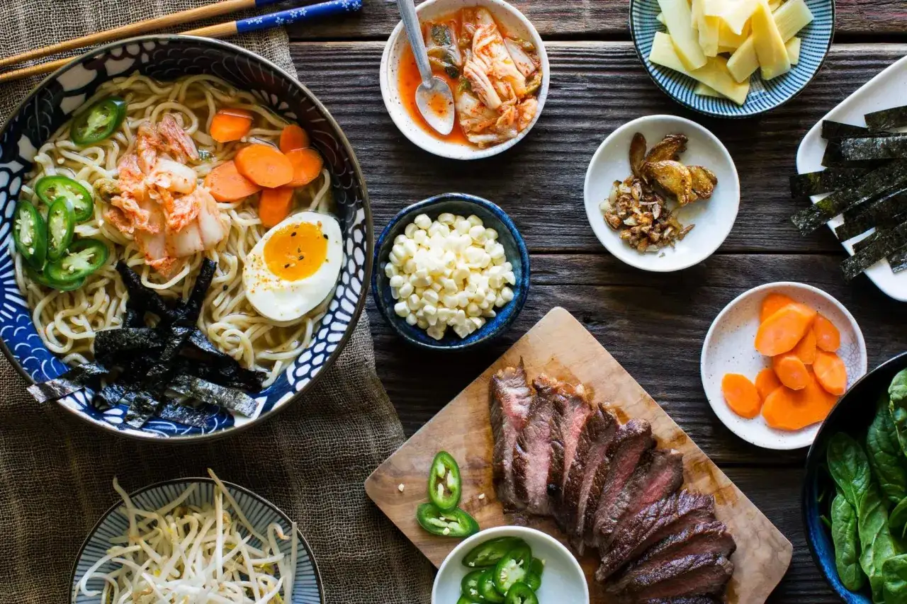 Miseczka ramenu z dodatkami: jajko, marchewka, kimchi, nori, kukurydza, fasolka, wołowina i jalapeno.