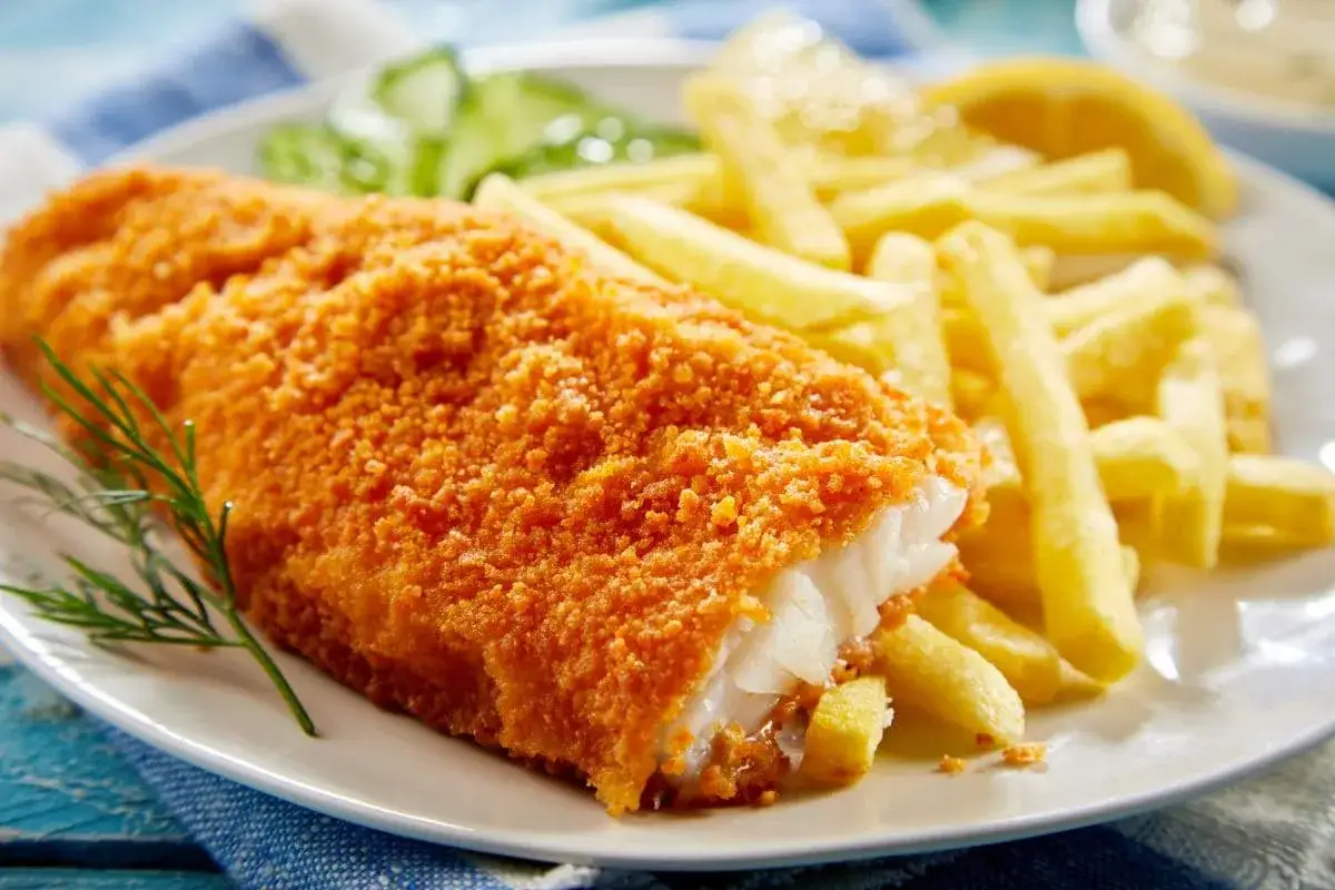 Chrupiąca ryba w panierce z frytkami i cytryną. Idealne jakie przyprawy do ryby smażonej? Koperek i pieprz.
