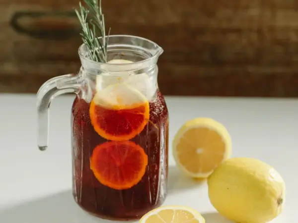 Dzbanek orzeźwiającej sangrii z pomarańczą i cytryną, z gałązką rozmarynu. Idealna na upalne dni.