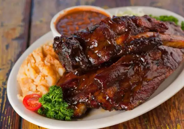 Soczyste żeberka w sosie BBQ, podane z puree ziemniaczanym i fasolką. Idealne pytanie: jakie przyprawy do żeberek?