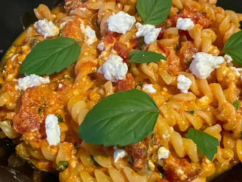 Pyszne fusilli z sosem pomidorowym, kawałkami sera feta i świeżą bazylią. Idealne danie dla miłośników pomidorów z fetą.